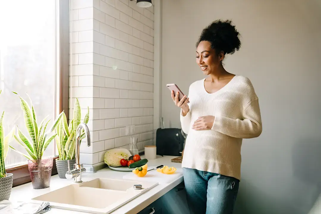 pregnant woman in kitchen on phone