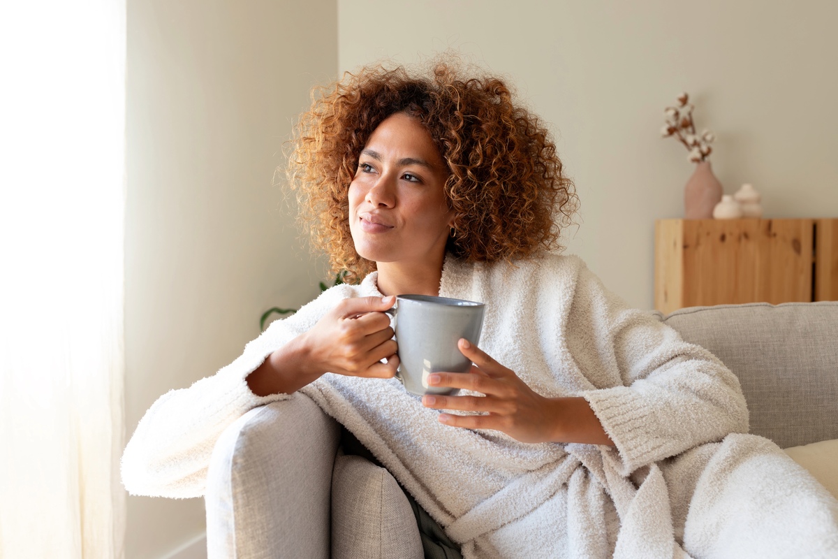 Woman drinking tea and looking out the window