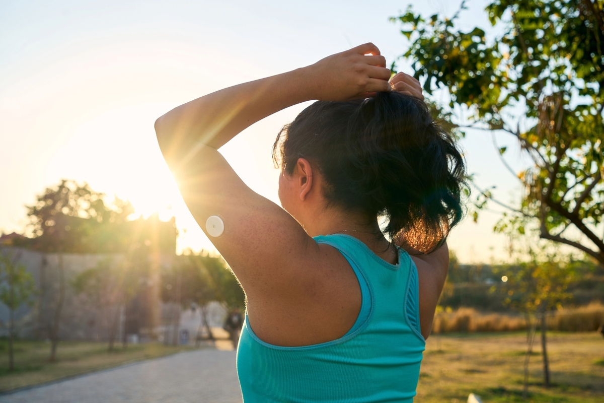 Woman with glucose monitor tying hair